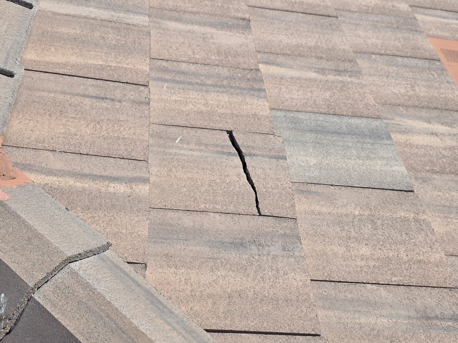 Cracked roof shingle found during a roof inspection
